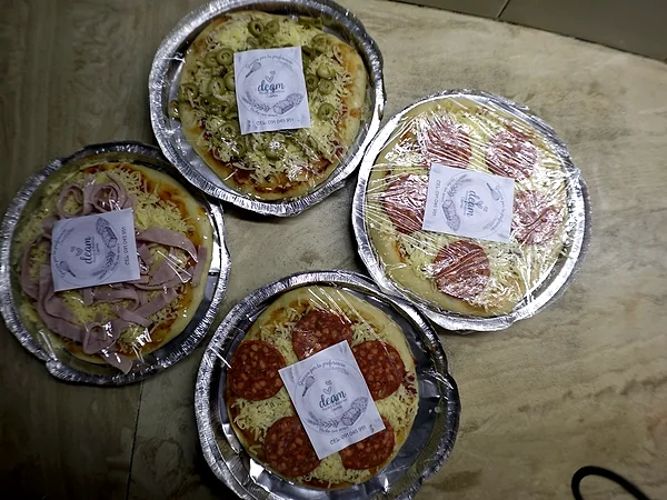 Una mesa con pizzetas Deam de jamón, salame y aceitunas